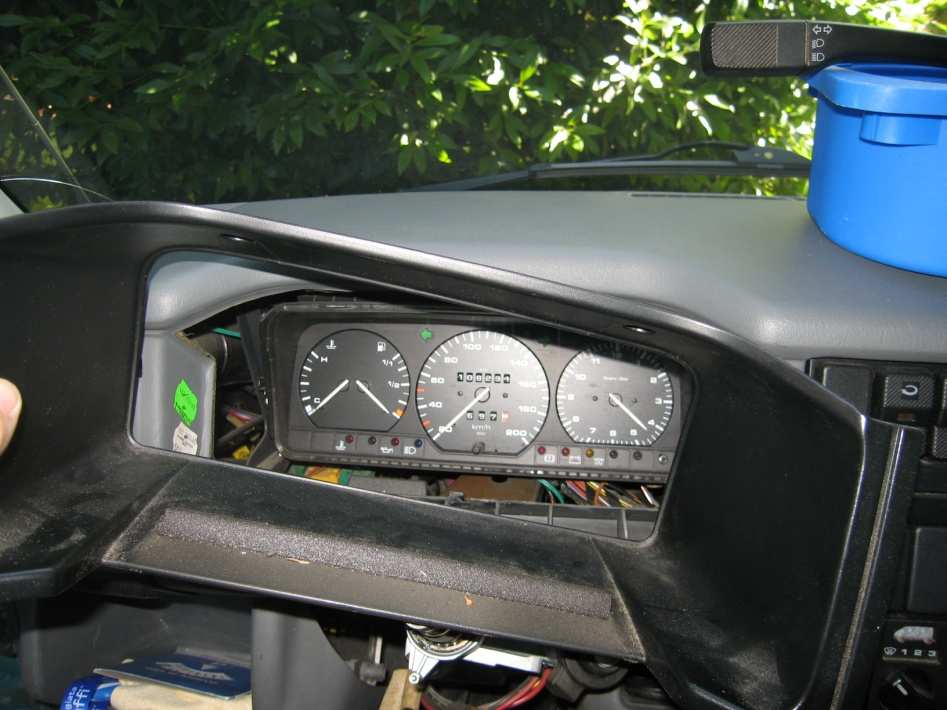 The black instrument cluster surround being pulled out of the dashboard