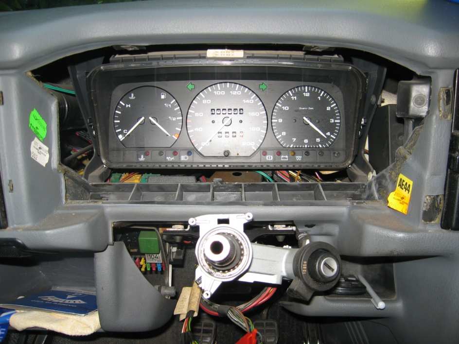 Instrument cluster exposed in the dashboard without its surround, with the bare steering column in front