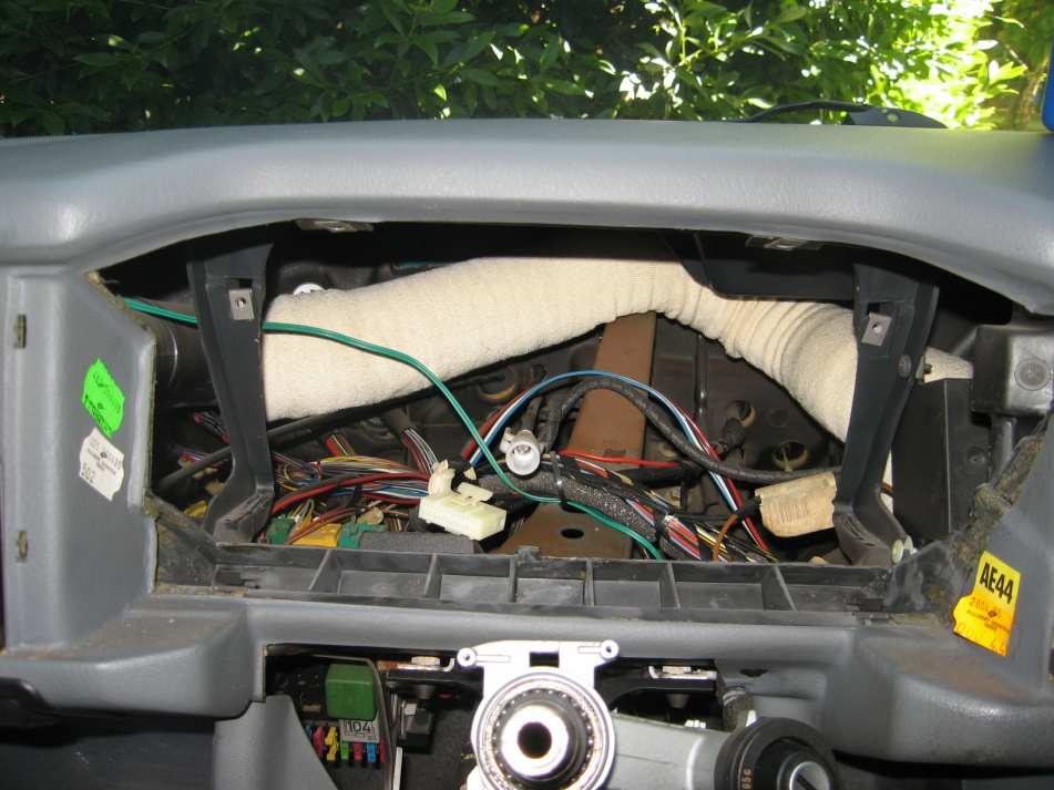 The empty instrument cluster housing with the wiring, the white connector and the speedometer cable