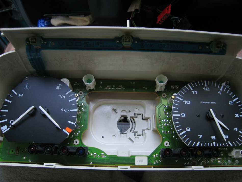 Instrument cluster with the front removed: temperature and fuel gauges on the left, clock on the right, speedometer already out