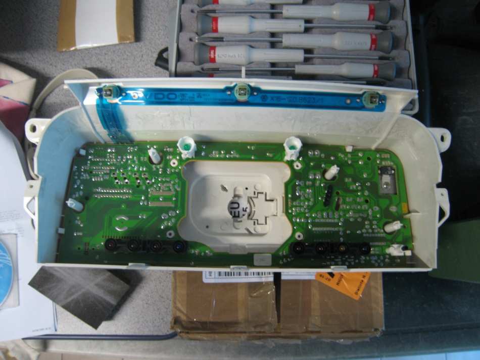 The green circuit board of the instrument cluster in its white housing, with the gauges removed