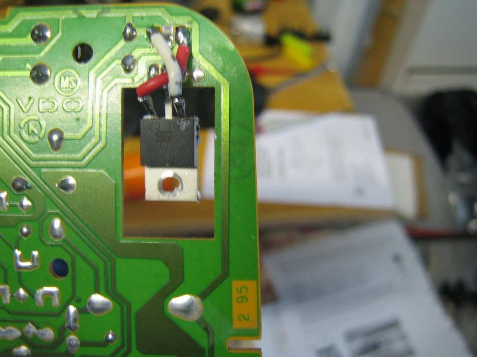 The new regulator fitted to the board, connected with a red and a white wire crossed over