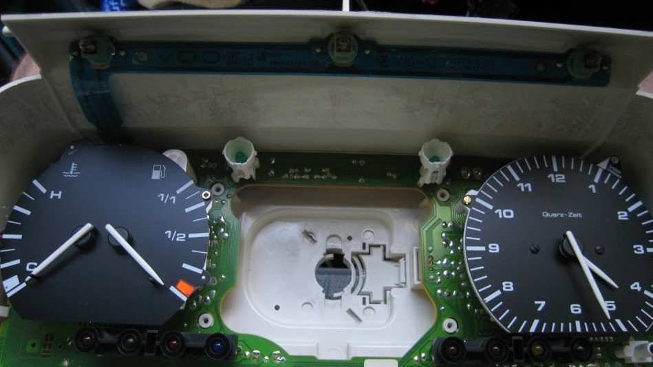 T4 instrument cluster open on the bench with the front removed: temperature and fuel gauges, clock and green circuit board