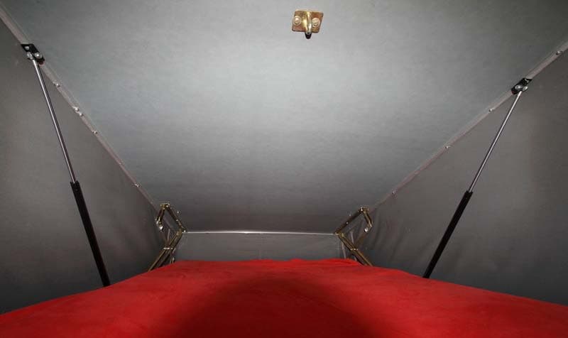 Inside the raised pop-top roof with the two gas struts fitted at the sides, between the scissor hinges and the roof