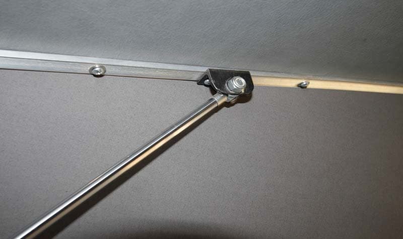 Option A: eyelet end of the strut bolted to an L-shaped bracket under the roof profile