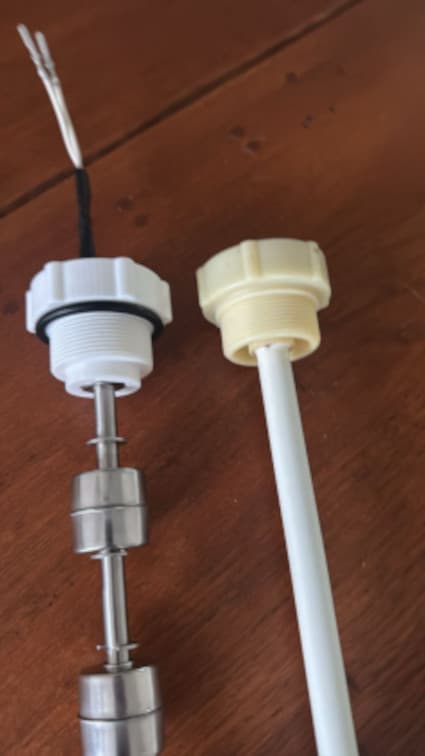 The new sensor with 3D-printed cap and stainless steel floats, next to the original sensor