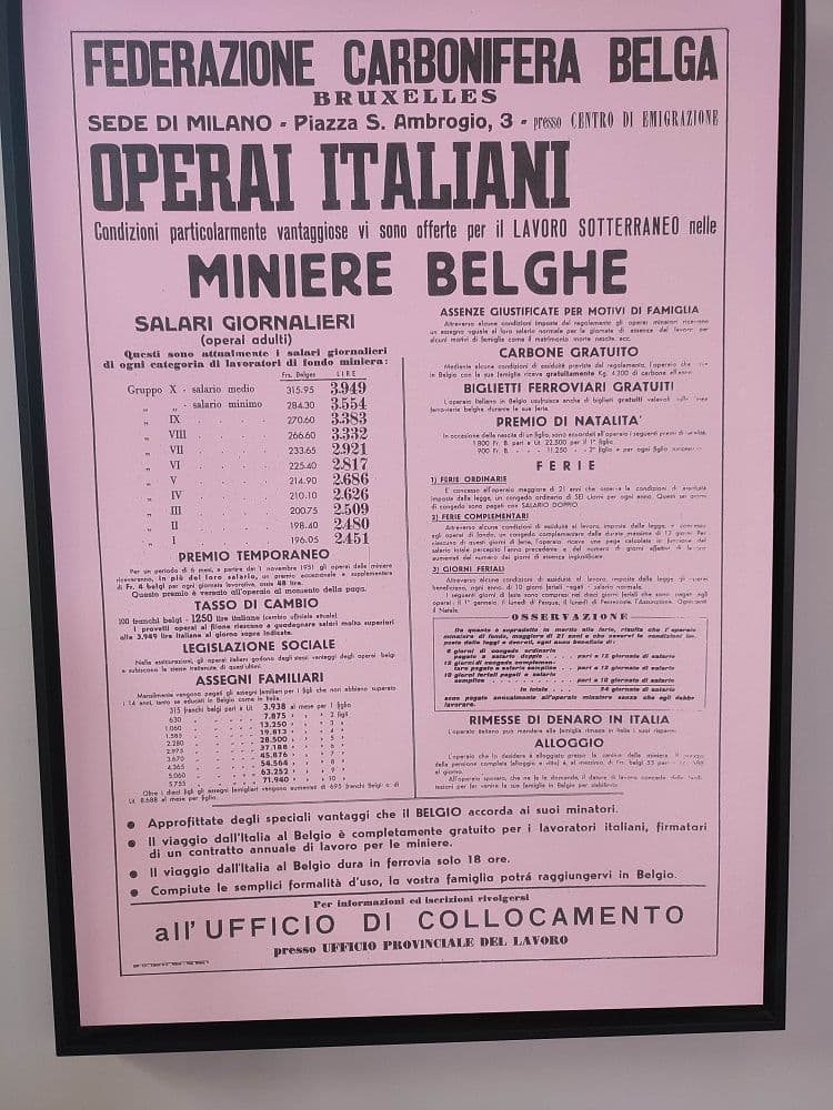 The pink poster of the Belgian coal federation seeking Italian workers for the mines, with wages, bonuses and travel conditions