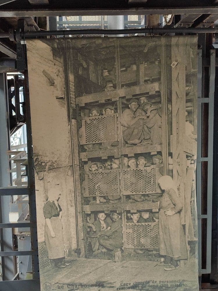 An old image of the mine cage, loaded with miners on several levels